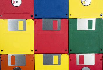 Horizontal close-up shot of nine multicolored plastic diskettes.  Shows fronts and backs of disks.