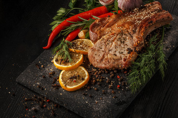 Grilled meat and vegetables on a black rustic background.