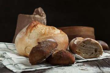 freshly baked bread on a wooden table on a dark background
