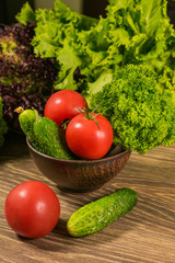 Tomatoes and cucumber. Fresh vegetables on a wooden table. Background of vegetables.