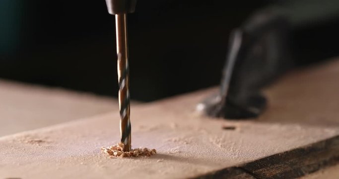 Drills the wooden plank