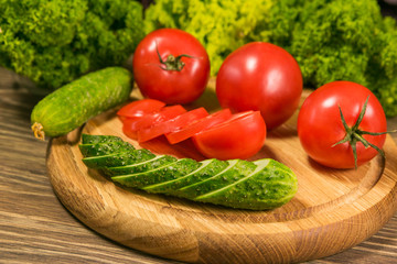 Fresh vegetables. Tomatoes and cucumbers on a wooden table