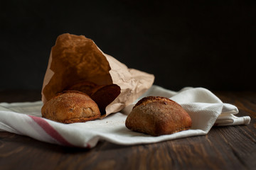 freshly baked bread on a wooden table on a dark background