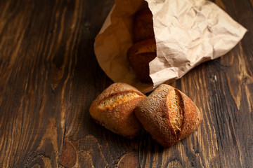 freshly baked bread on a wooden table on a dark background