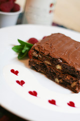 Stacked Chocolate brownie cake, raspberries, hearts, sauce, mint