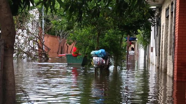 Long shot of a family rowing down a flooded street