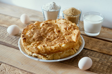 delicious cake, eggs, flour, milk and sugar placed on an old wooden table