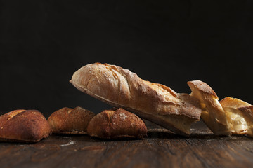 freshly baked bread on a wooden table on a dark background
