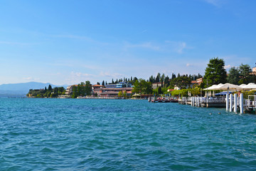 SIRMIONE, ITALY - The town of Sirmione, with restaurants by the blue water in summer