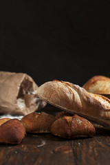 freshly baked bread on a wooden table on a dark background