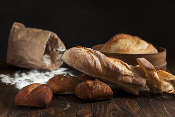 freshly baked bread on a wooden table on a dark background