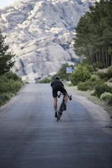 Rolgordijnen Cyclist climb the road near rocky mountains © David Fuentes