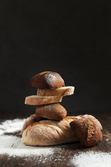 freshly baked bread on a wooden table on a dark background