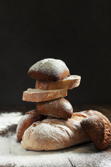 freshly baked bread on a wooden table on a dark background