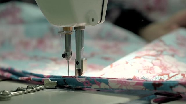 process of quilting on patchwork blanket close up sewing machine hands production