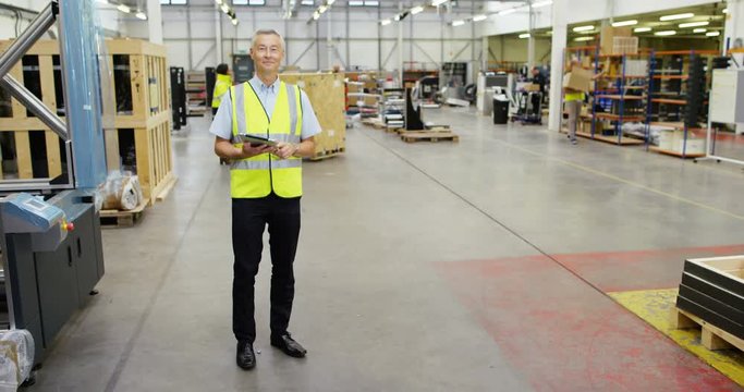 4k, Portrait of a mature man working inside in a distribution warehouse. Slow motion.