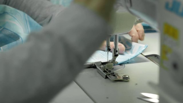 process of quilting on patchwork blanket close up sewing machine hands production