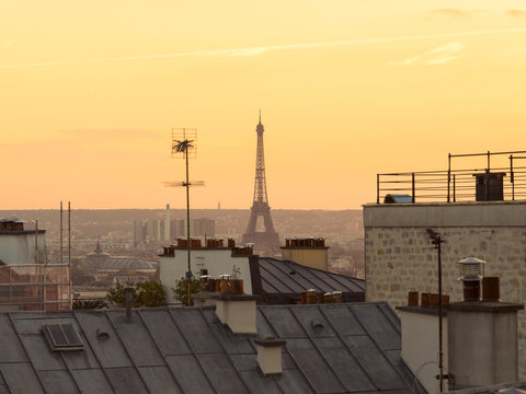 Sunset view of Paris rooftops from Montmartre, the artistic and touristic quarter. View of the Eiffel Tower. Paris, France.