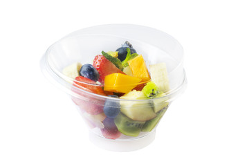 Fototapeta na wymiar Fruit salad with bananas, strawberries, berries, in plastic utensils on a white background.