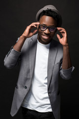 Portrait of a fashionable african american man smiling on black background