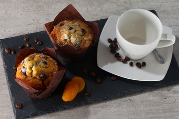 Two muffins and cup with coffee grain.