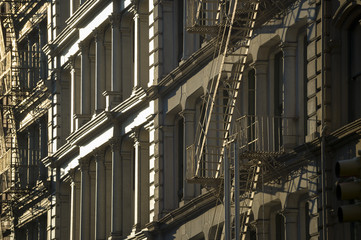 Close-up of fire escapes running down the facades of iconic cast iron buildings in Soho, New York City