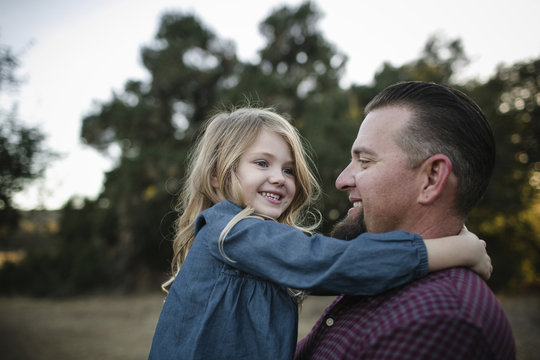 Cheerful father and daughter playing on field - Powered by Adobe