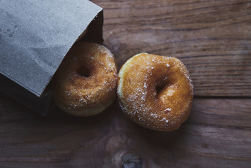 High angle view of donuts by paper bag on table