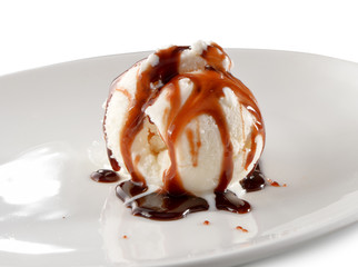 ice cream scoop topped with chocolate sauce on plate close-up isolated on white background
