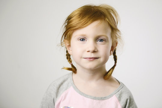 Portrait Of Smiling Girl Standing Against White Background