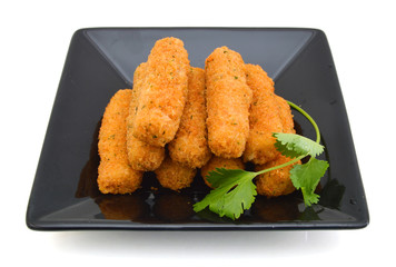 fried cheese sticks in blck plate on white