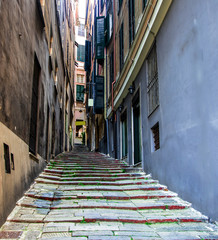A narrow alley with stone staircase in the ancient center of Genoa, Italy.