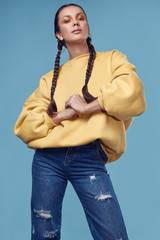Beautiful charming hispanic girl in jeans and yellow hoody