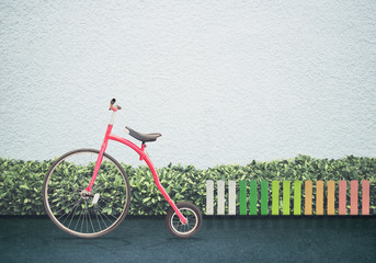 Red vintage bicycle with on  road in front of whte birck wall. background for display product or business text concept for in summer