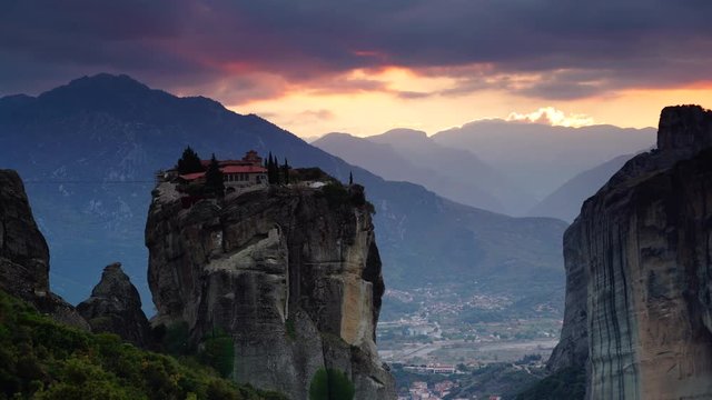 Scenic sunset sky over holy Trinity monastery on cliff in Meteora, Thessaly Greece. Greek destinations. Time lapse