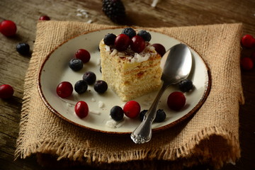Piece of cake napoleon on a plate with sweet fresh berries