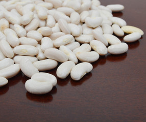 Fototapeta na wymiar White kidney beans top view close up isolated on red background