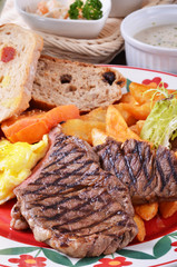 Closeup of beefsteak  with french fries and vegetables   