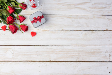 Romantic table Red roses/gift box and hearts on old white wood table/Valentines day background.