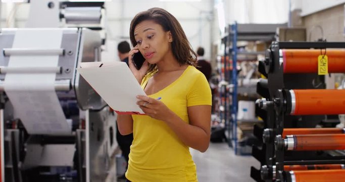 4K Confident female business manager in print factory doing business over the phone. Slow motion.