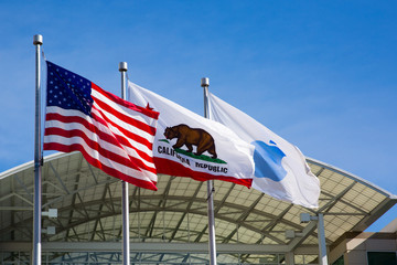 Flags in front of Apple headquarters: American, Californian and blue Apple flag