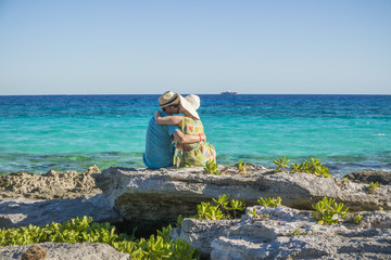 LOve Story. Kissing couple sitting on rocks