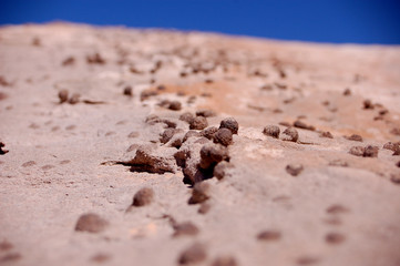 Small round rocks desert close up with fade into blue sky