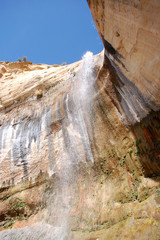 looking up at cascading desert water fall southern utah red rocks