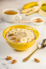 Oatmeal with banana and honey. Porridge in a yellow bowl