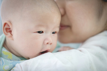 Asian mother and baby son plays at home.