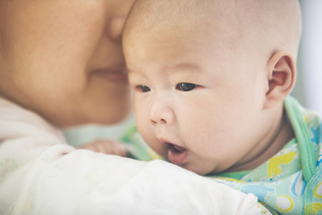 Asian mother and baby son plays at home.