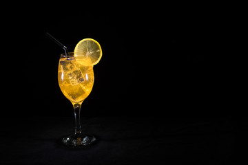 Cold orange lemonade in a glass with ice cubes