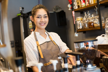 Asian barista woman make a coffee at bar.