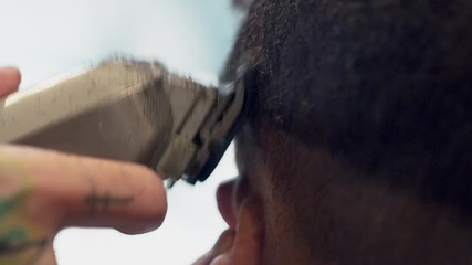 Handheld shot of barber trimming customer's hair
